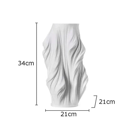 A tall white decorbites ceramic vase with a sculpted flowing design and purple flowers for bedroom decor