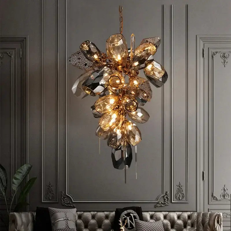 Sculptural gold pendant light with glass shades featuring faceted amber crystals and mirrored elements for dining room