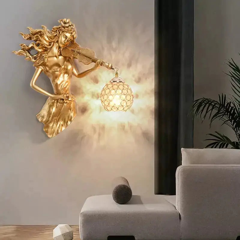 Gold sculptural wall lamp featuring violinist figure with flowing hair and crystal spherical lampshade for living room