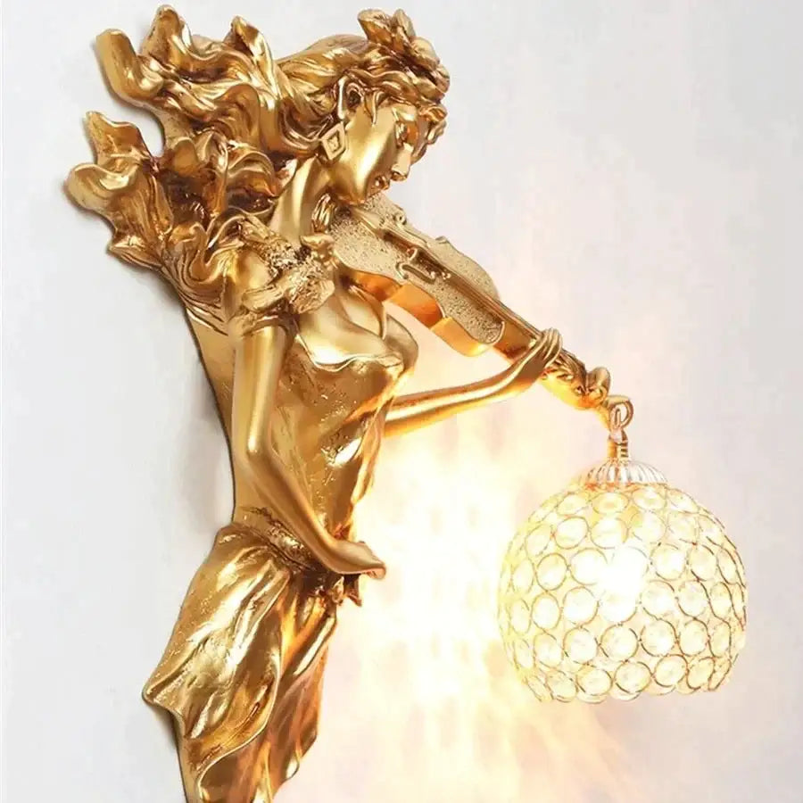 Sculptural gold violinist crystal wall lamp featuring a female figure with flowing robes and ornate crystal globe lampshade