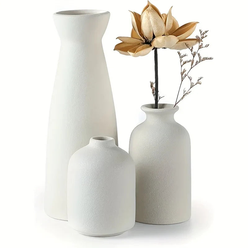 Set of 3 white ceramic vases with textured surfaces and varying heights featuring a dried golden lotus flower for modern farmhouse decor