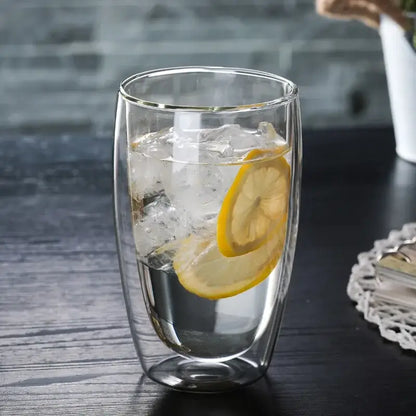 Set of 3 clear double wall glass cup tumblers filled with ice and lemon slices for kitchen and dining use