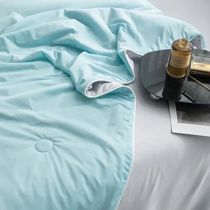 Soft light blue quilted cooling queen quilt with subtle sheen and white piping ideal for summer comfort
