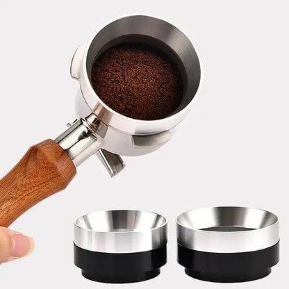 A stainless steel espresso coffee filter with wooden handle filled with ground coffee and two black silver tampers