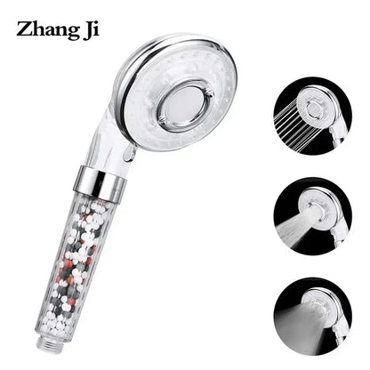 Silver and clear high pressure shower head with transparent filter housing containing white black and orange beads