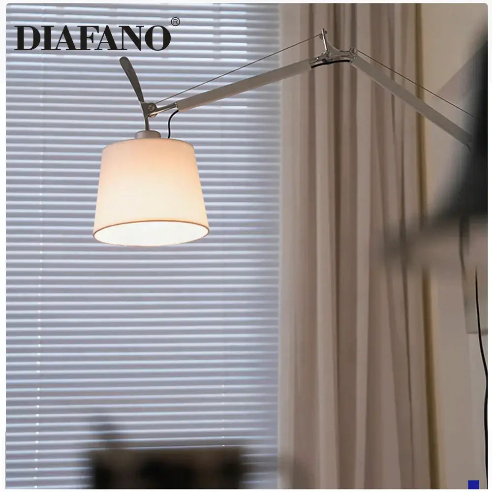 A sleek silver and cream decorbites adjustable wall lamp with long swing arm and off-white fabric shade for reading