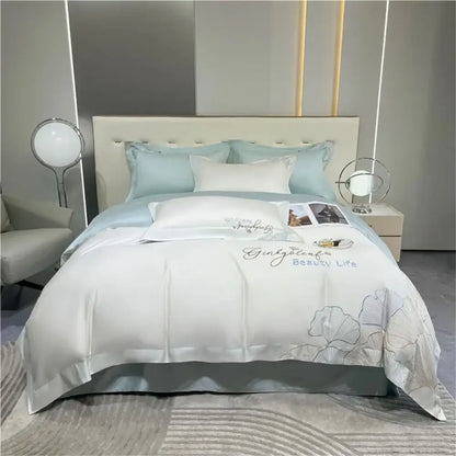 White satin duvet cover with silver embroidered ginkgo leaf and script paired with light blue pillows in 1200tc embroidery egyptian cotton bedding set