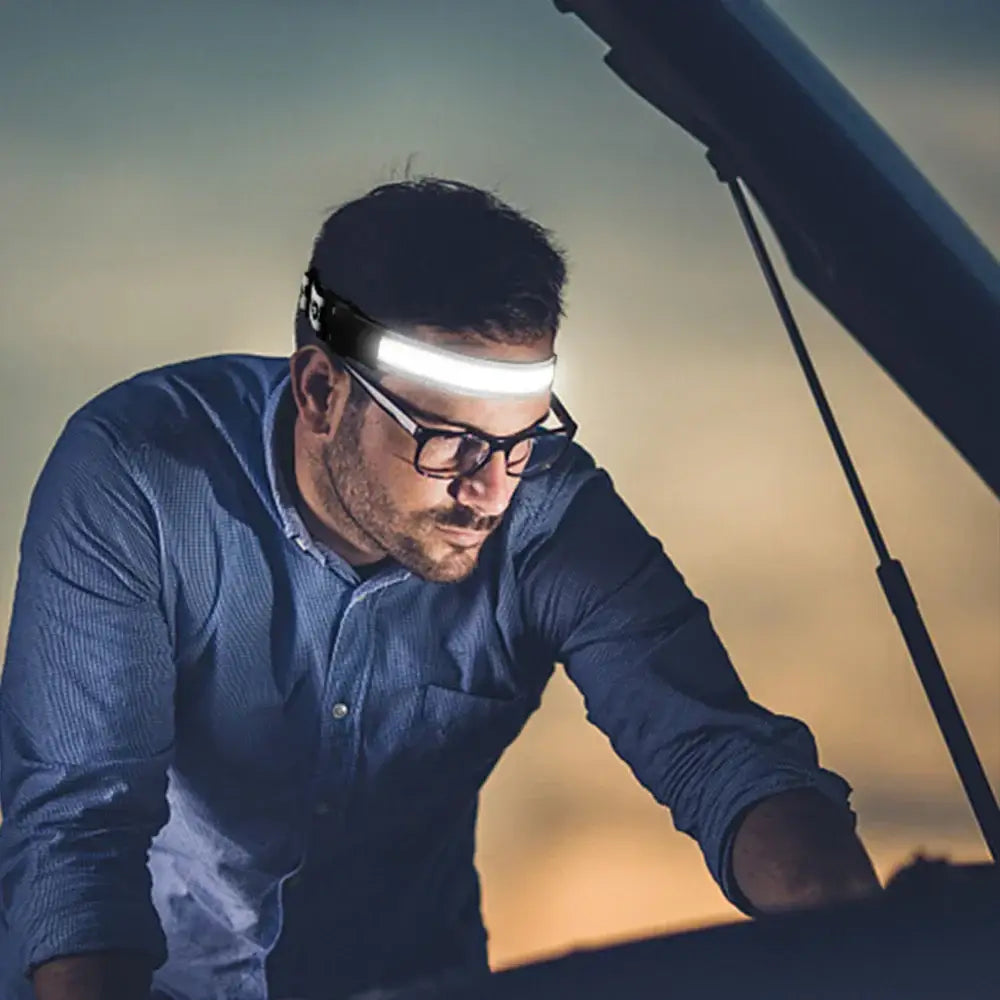 Man wearing a sleek black and gray decorbites cob led sensor headlamp with adjustable strap for garage work light