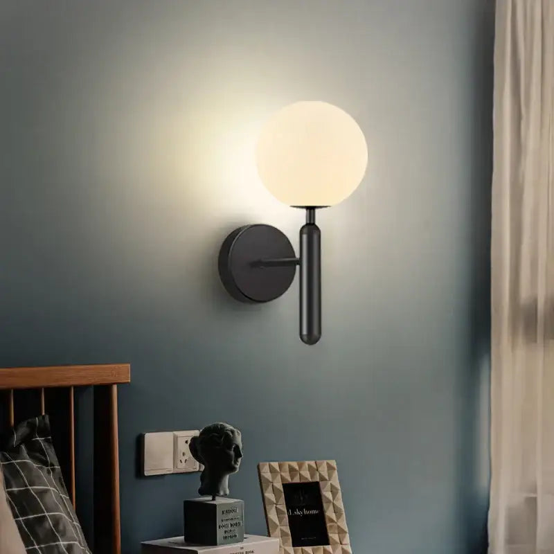 Sleek black matte wall sconce lamp with a frosted glass sphere for modern corridor lighting