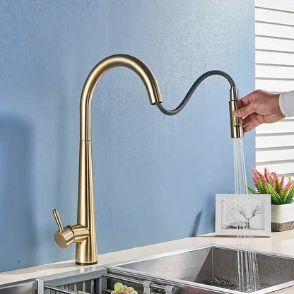 Sleek gold swivel kitchen faucet with a curved gold-toned spout and flexible black pull down sprayer hose decorbites gold swivel