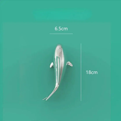 A sleek silver whale-shaped metallic wall hanging ideal as decorbites goldfish resin goldfish resin wall art decor