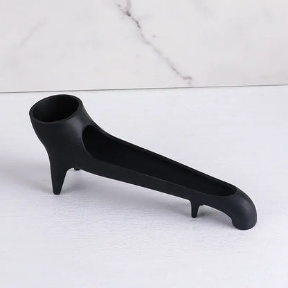 Black matte ceramic ashtray with three pointed feet and handle shown alongside sleek gray silicone water tank deflector