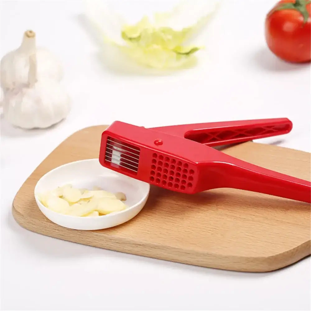 Sleek red manual press garlic crusher with textured grip and metal slicing blades by decorbites garlic crusher