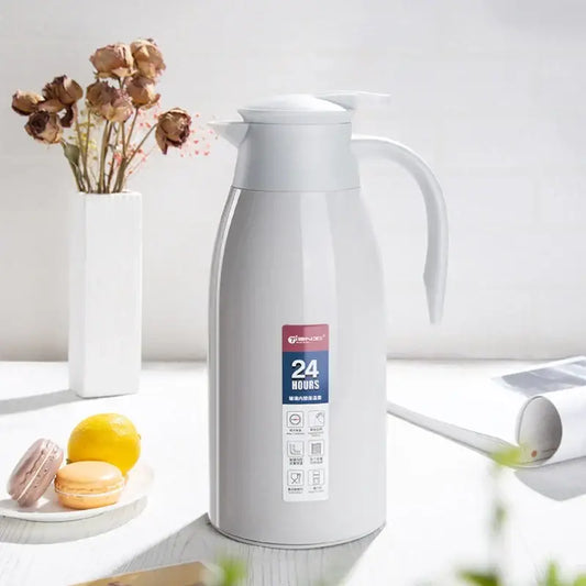 A sleek silver stainless steel decorbites insulavacuum bottle with white lid and handle for kitchen use