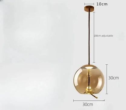 Sleek smoked glass led chandelier featuring an amber glass globe with brass fixture and adjustable black cord pendant light