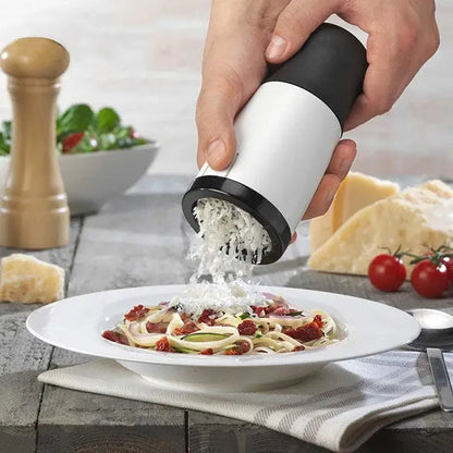 A sleek white and black handheld decorbites herb grinder chopper slicer grates parmesan over pasta for kitchen use
