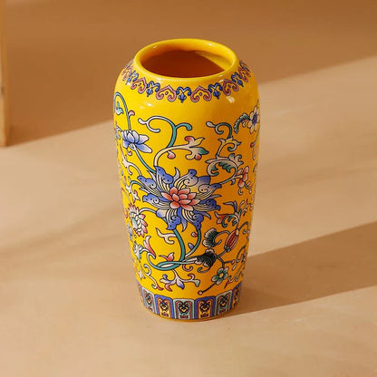 Small ceramic vase in vibrant yellow ceramic with intricate blue pink green floral patterns for office and home decor