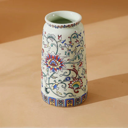 A small white porcelain vase with colorful red blue and gold floral patterns for decorative home and office use