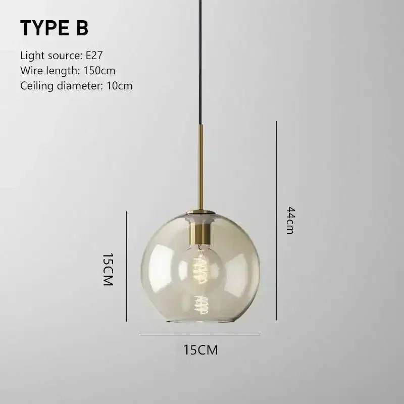 Smoked glass pendant light with clear globe and brass finish featuring exposed edison bulb for dining room use