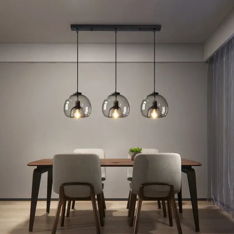 Modern black metal pendant lights with three spherical smoked glass pendant shades for dining room table lighting