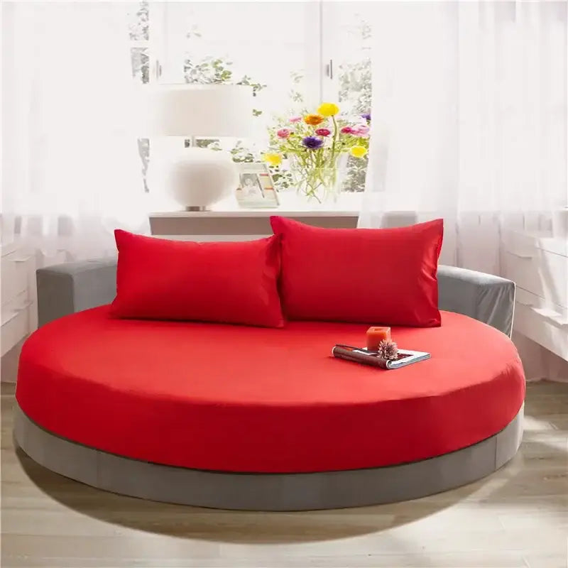 Soft dark gray cotton round bed sheet set on a round bed with vibrant red fabric upholstery and matching red pillows decorbites cotton round