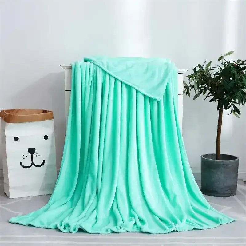 Soft gray cozy flannel warm plush throw blanket in mint green draped on white dresser for decorbites cozy flannel use