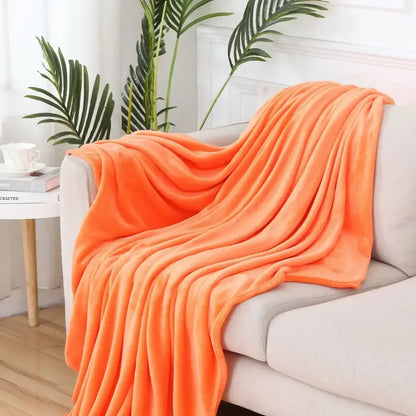 A plush vibrant orange throw blanket showcasing decorbites cozy flannel warm fabric draped over a sofa