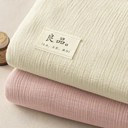 Stacked cotton muslin fabrics in off-white and blush pink paired with soft light gray decorbites cotton fitted sheet