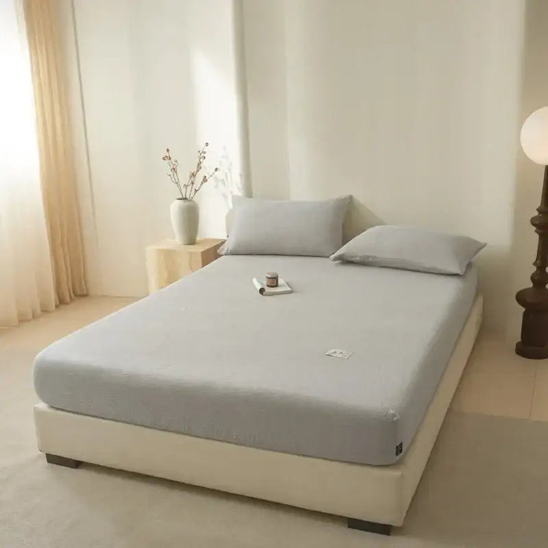Soft light gray cotton fitted sheet with soft texture subtle stitching and small embroidered logo decorbites cotton fitted sheet