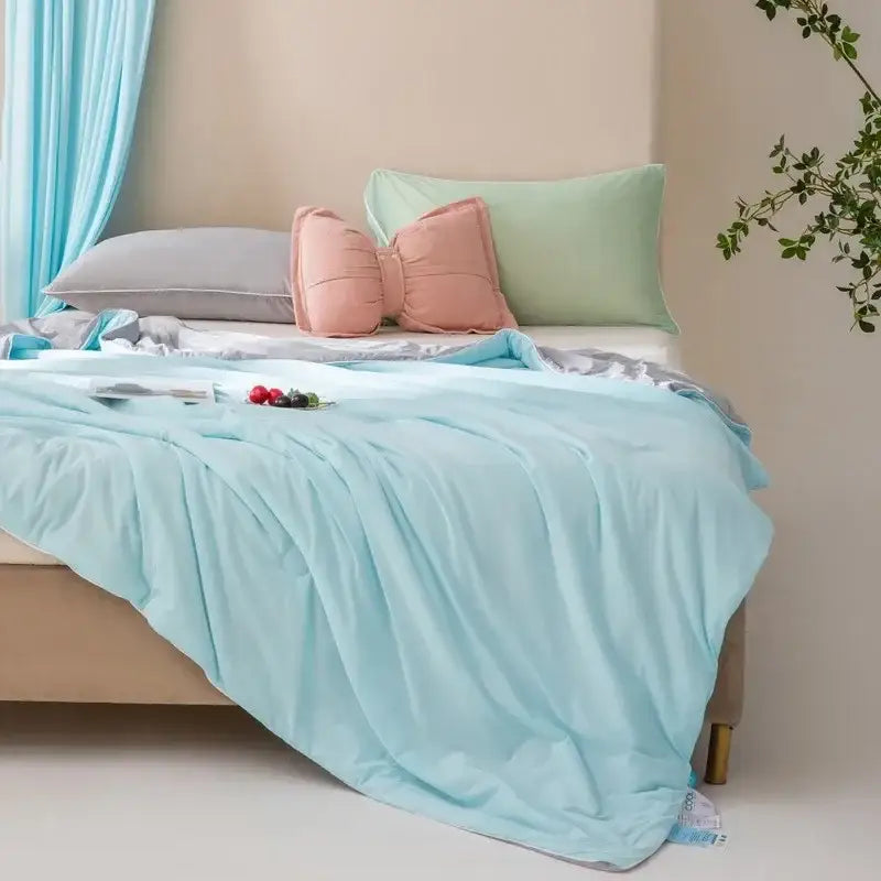 Soft mint green cooling quilt with light blue quilted bedspread featuring subtle sheen and soft flowing folds by decorbites cooling quilt
