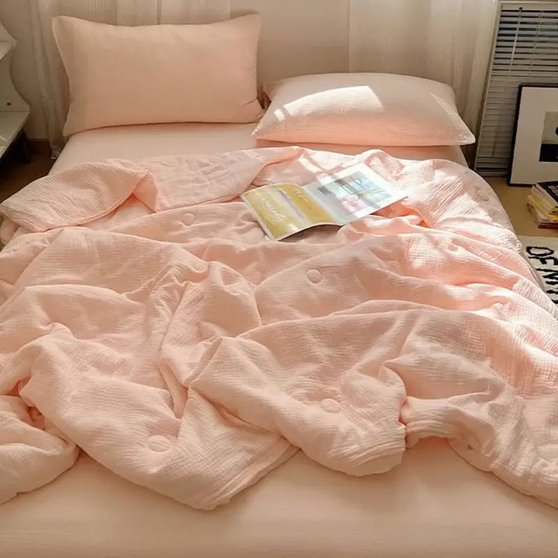 Soft peach cotton muslin cooling wrinkled yarn quilt with subtle texture and button closures for bedroom use