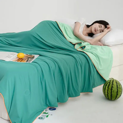 Soft teal and gold decorbites cool fibre summer quilt draped over a sleeping woman for a cool fibre summer bedroom blanket