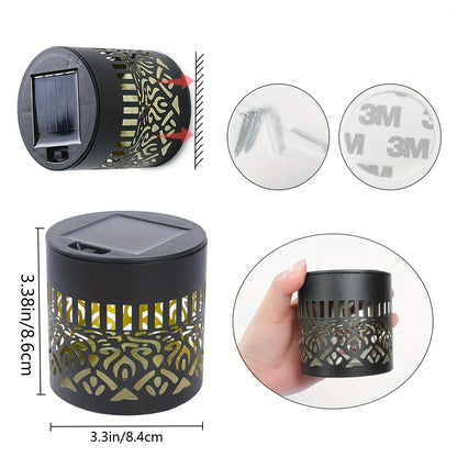 Black cylindrical solar-powered datura lantern light with gold cutout patterns and built-in solar panel for garden decor