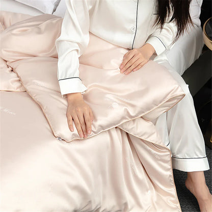 A soft blush pink silk quilt pillowcase with subtle black piping for the sondeson luxury natural silk quilt comforter