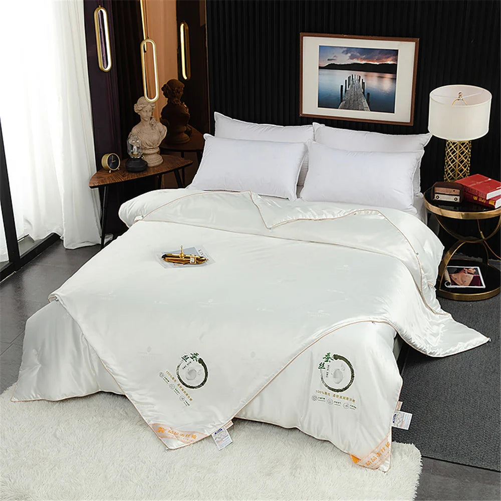 Sondeson luxury white satin-finish silk quilt with subtle embroidered logo and gold trim for queen and king beds