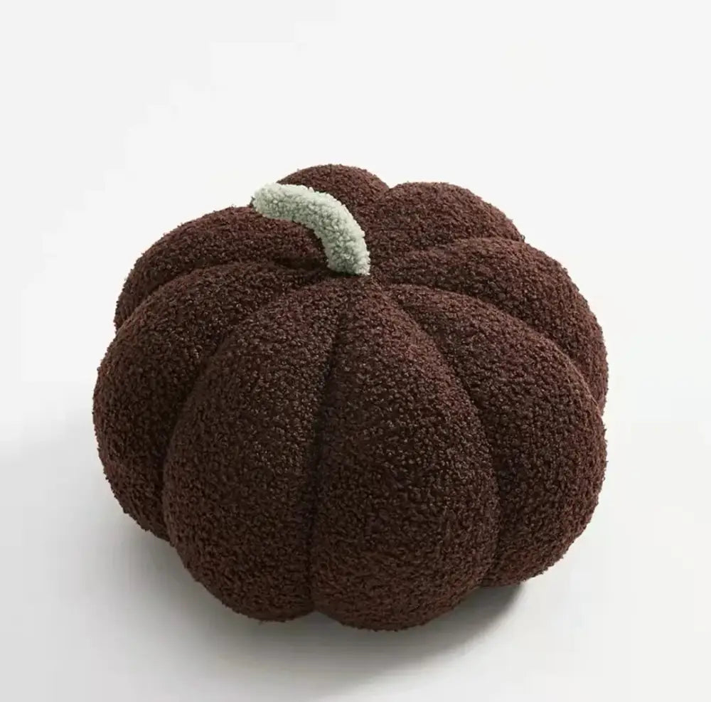 A plush dark brown decorbites 3d pumpkin throw pillow with soft fleece texture and light green stem for living room decor