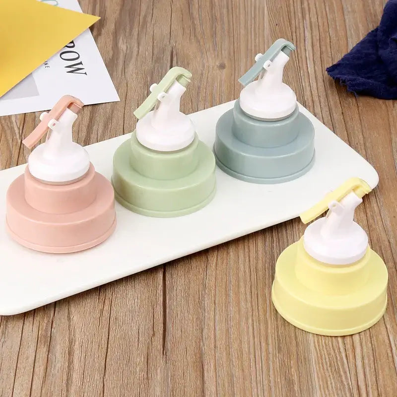 Pastel-colored plastic squeeze bottles with white pump nozzles and matching caps featuring stainless steel bottle cap stopper handles