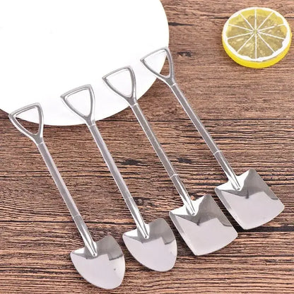 Set of four shiny stainless steel teaspoons shaped as miniature shovels with triangular handles on wood surface
