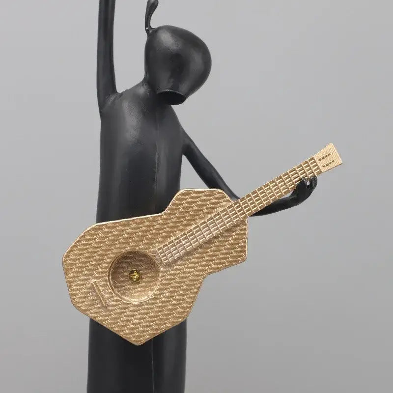 Stylized black and gold guitarist resin figure holding a textured guitar for living room decorbites guitarist resin sculpture