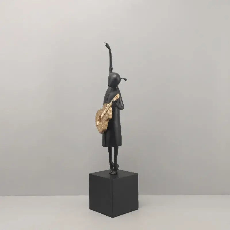 Stylized black and gold guitarist resin figure on cube base ideal for decorbites guitarist resin and resin figure sculptures