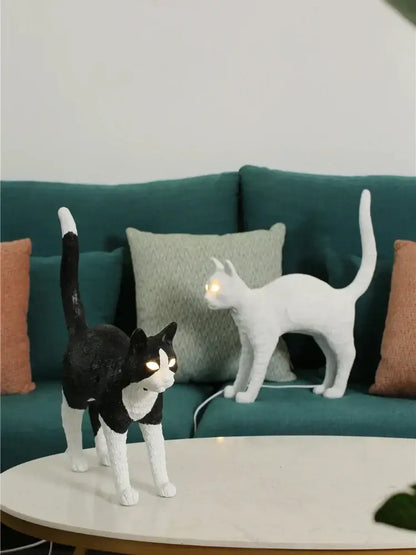 Stylized black and white cat resin table lamp with glowing eyes made of smooth plastic by decorbites black cat for bedroom decor