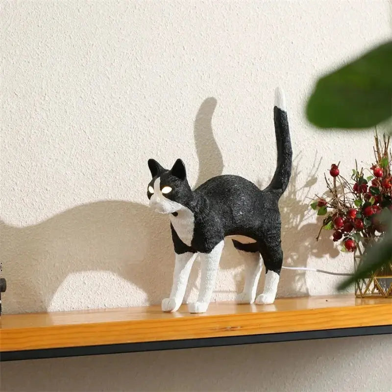 Stylized black and white cat resin table lamp with glowing eyes made from textured resin for bedroom decorbites black cat