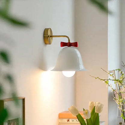 White ceramic bell-shaped wall lamp with gold-finished metal arm and red bow decorbites bowknot bell wall accent