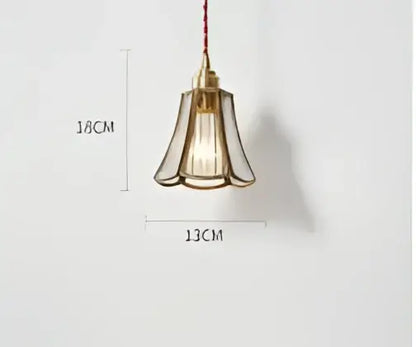 Teal blue glass pendant light with brass hardware featuring a brass-toned fluted glass shade and exposed filament bulb
