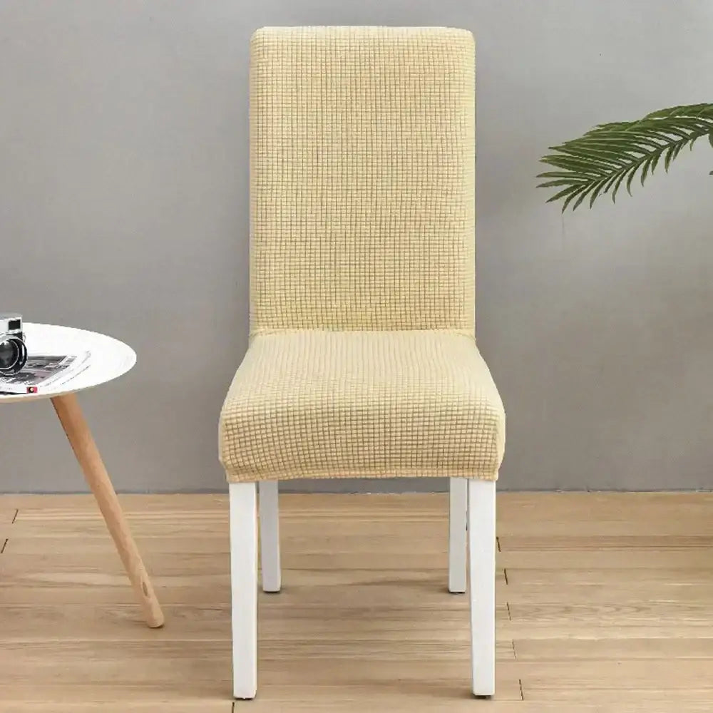 Beige textured stretch chair cover with subtle grid pattern complementing decorbites blue quilted chair protector