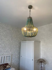 Teal blue wood beads pendant light with a woven metal frame and warm glowing bulbs for bedroom decorbites blue wood beads