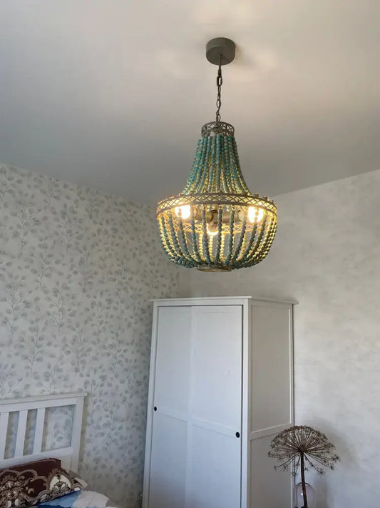 Teal blue wood beads pendant light with a woven metal frame and warm glowing bulbs for bedroom decorbites blue wood beads