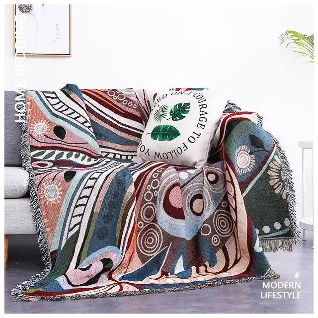 A colorful sofa blanket with dustproof butterfly carp pattern and fringe edges in pink, blue, green, and beige tones