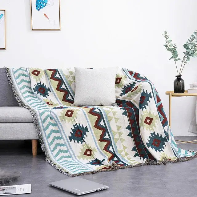 A cozy cream sofa blanket with dustproof butterfly carp pattern in teal red and olive green with fringed edges