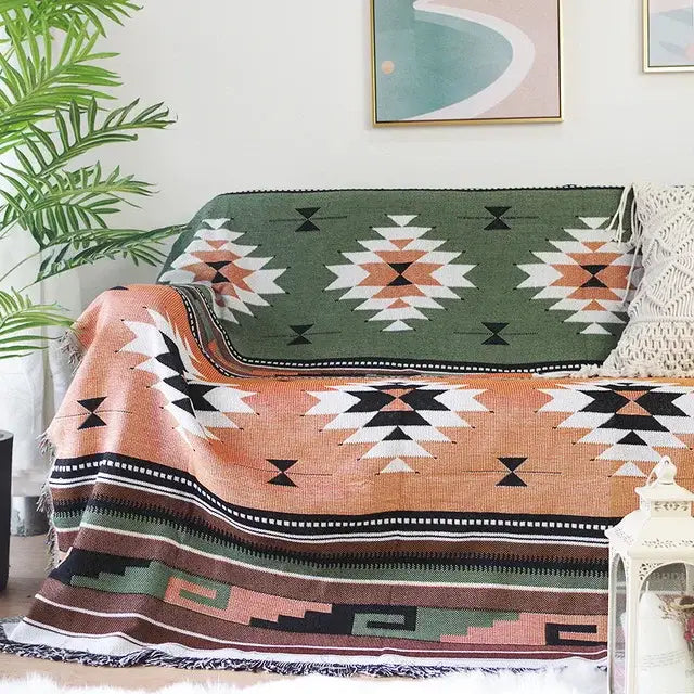 A cozy woven sofa blanket with a dustproof butterfly carp pattern in green orange black and white draped over a sofa
